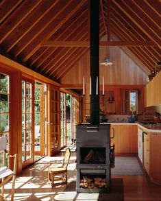 a kitchen with wood floors and a stove in the center, surrounded by wooden walls