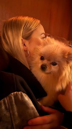 a woman holding a small dog in her arms