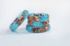 two blue rings with gold flakes on them sitting next to each other in front of a white background