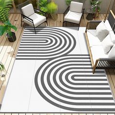 a white and black area rug on top of a wooden floor next to two chairs