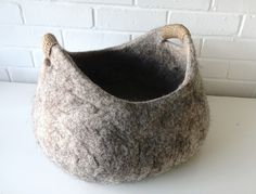 a gray and black basket sitting on top of a white table