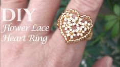 a heart shaped ring is shown with flowers on the inside of it, and in front of a green background that says diy flower lace heart ring