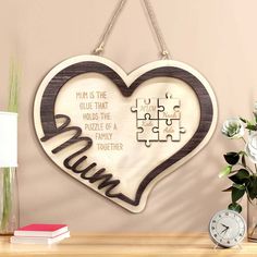 a wooden heart shaped puzzle hanging on a wall