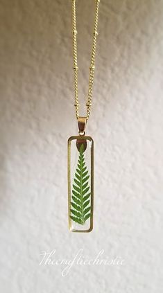 Welcome a little piece of nature and enjoy this beautiful Fern necklace pressed before encapsulating them with resin in an open back bezel. The pendant measures 40x10 mm and come with a beautiful gold chain. All pendants and necklaces are nickel and lead free! The petals and leaves have been carefully preserved to retain their color and would make a great gift for your loved ones. This piece was made with real fern and hence it is important to preserve the jewelry in the box provided safely away Plant Necklace, Pressed Fern, Fern Necklace, Pressed Flower Jewelry, Silver Dragon Necklace, Mystical Jewelry, Horn Jewelry, Brown Necklace, Jewelry Ads