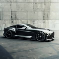 a black sports car is parked in front of a concrete wall and cement flooring