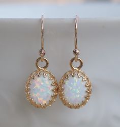 "Stunning earrings made using lab created opal gems and 14K gold filled. Each opal is white in color with colorful flashes with each turn of the stone. The opals are hand set into 14K gold plated premium crown bezel settings. They hang from 14K gold filled french earwires. Opals each measure 10mm tall (just shy of 1/2\") while entire earring length is 1\". PREFER SILVER? Just leave a note at checkout and I can gladly make in sterling silver. Made to match this necklace and bracelet: https://www. Gold Opal Jewelry, Opal Jewelry Earrings, White Opal Earrings, October Birthstone Jewelry, Swarovski Crystal Jewelry, Swarovski Crystal Bracelet, Wedding Jewelry Bracelets, October Birthstone, Opal Earrings