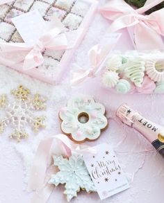 a bottle of champagne next to some cookies and other items on a table with snowflakes