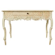 an antique white console table with drawers and carvings on the top, against a white background