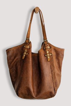 Elevate your hobo style with our exquisite Soft and Slouchy Hobo in Stone Washed "Cognac On the Rocks". The luxurious design features a magnetic closure and a spacious interior, while the vintage brass snap and buckle details add a unique, edgy touch. Its comfortable extra long shoulder straps and thoughtful large center zip section make it both chic and practical. Embrace the rebel within and make a statement with this genuine piece of art and truly rebellious companion. Each bag is a unique, h Leather Artist, Hobo Style, Leather Finish, Luxurious Design, Best Bags, Raw Gemstones, Tote Backpack, New Bag, Hobo Bag