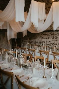 the tables are set with white linens and candles