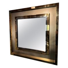 a square mirror with gold trim around the edges