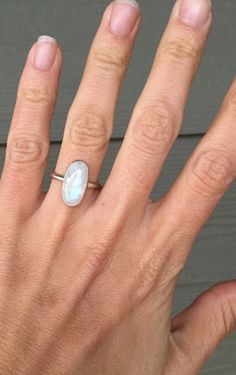 A beautiful oval rainbow moonstone has been set in sterling silver with a hand made ring band from sterling silver half dome wire. The moonstone is 16mm x 8mm in size. Simple and elegant in size! Made to order! Choose your setting, vertical (north to south) or horizontal (east to west). Moonstone is the birthstone for June! June Birthstone Ring, Ring Moonstone, Moonstone Ring Sterling Silver, June Birthstone, Window Shopping, Half Dome, Moonstone Ring, June Birth Stone, Ring Band