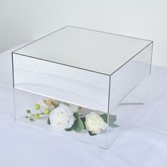 a clear box with white flowers in it