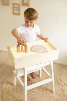 a young boy playing with wooden pegs on a small table in the living room