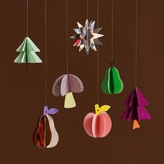 an assortment of paper ornaments hanging from strings