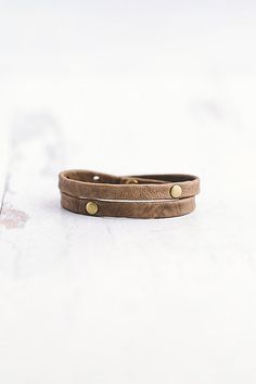 Made for the true warrior, our Double Warrior wrap is a narrow leather bracelet that wraps around the wrist twice and features two flat antique brass rivet accents. **Contents** * Lambskin leather, antique brass hardware * Button clasp closure * Handmade **Care/Import** * Made in the USA **Dimensions** * Adjustable to fit wrist sizes 6.5”-8” | Giving Bracelets Antique Brass Double Warrior Wrap Bracelet at Free People in Grey Everyday Double Band Leather Bracelet, Adjustable Gold Leather Wrap Bracelet, Adjustable Gold Bracelets With Brass Hardware, Brown Leather Bracelets With Brass Hardware, Adjustable Vintage Leather Bracelet With Rivets, Vintage Adjustable Leather Bracelet With Rivets, Adjustable Leather Strap Wrap Bracelet For Everyday, Adjustable Leather Bracelet With Rivets For Gift, Adjustable Leather Bracelet With Rivets