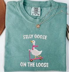 Comfort Colors Embroidered Shirt Silly Goose On the Loose Tshirt Goose Crewneck Shirt Silly Goose T-Shirt Funny Shirt Gift,  MADE IN USA PLEASE NOTE THAT THE PICTURES ON THE LISTING ARE SAMPLES ONLY. If interested in adding embroidery to the sleeve please go to this listing: https://www.etsy.com/listing/1674502020 Because it is made to order, we don't accept the return or exchange unless we make a mistake We are unable to replace or refund purchases based on the color and the font selections. Pl Green Casual T-shirt With Embroidered Text, Casual Green T-shirt With Embroidered Text, Casual Green Tops With Embroidered Graphics, Casual Green Top With Embroidered Graphics, Casual Cotton Shirt With Embroidered Text, Embroidered Crew Neck Graphic Tee Shirt, Graphic Tee Shirt With Embroidered Graphics And Crew Neck, Graphic Tee With Embroidered Graphics And Crew Neck, Casual Crew Neck Shirt With Embroidered Text