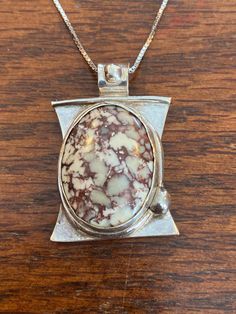 This gorgeous Crazy Lace Agate (also known as the Rosetta Stone) has been set in fine silver and hangs on an 18" sterling box chain.  It is a heafty stone, so the pendant is a bit heavier than a typical piece of this size. This pendant measures 1" x 1 1/2" . Artisan Silver Necklace With Rectangular Pendant, Sterling Silver Necklace With Large Oval Stone, Elegant Nickel-free Necklace With Rectangular Pendant, Bohemian Sterling Silver Necklace With Large Stone, Unique Sterling Silver Necklace With Rectangular Pendant, Oval Sterling Silver Necklace With Large Stone, Spiritual Sterling Silver Necklace With Large Stone, Artisan Agate Nickel-free Necklaces, Nickel Free Artisan Agate Necklaces