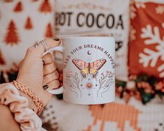 a woman is holding a coffee mug with a butterfly on it and the words, your dreams have come true