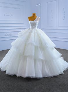 a white wedding dress on a mannequin in front of a white wall and floor