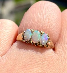 A glowing vintage natural trilogy opals set in solid 9karat yellow gold. The oval opals have flashes of purple,  yellow, red, green and blues depending on the light! Full English Birmingham hallmarks, this stunner is in superb vintage shape. US size 5, weighs 2.23 grams. Very comfortable and an absolute necessity in your ring collection! Thank you for looking! We do our best to list all item details and imperfections, however please keep in mind these are vintage, pre-loved items that may come n Vintage Opal Jewelry For Anniversary, Heirloom Opal Ring Collectible, Heirloom Style Collectible Opal Ring, Classic Three Stone Oval Opal Ring, Antique Style Round Opal Ring, Vintage Yellow Gold Opal Jewelry, Vintage Opal Jewelry In Yellow Gold, Antique Opal Jewelry In Yellow Gold, Classic Ethiopian Opal Jewelry For Anniversary