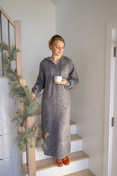 a woman standing on some stairs holding a cup