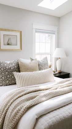 a bed with white sheets and pillows in a bedroom