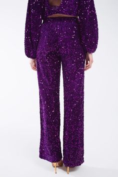 Make a bold statement at the party with our Wide Leg Sequin Pants With Side Pockets in Purple, in a dazzling display of sequins. These super comfy pants combine elegance with comfort, ensuring you shine as the life of the party.  The full-length design and relaxed fit provide a chic and sophisticated look, while the wide leg adds a touch of glamour. The straight silhouette makes these pants versatile, suitable for various occasions and styles.  Featuring elegant side pockets and an elasticated waistband, these pants offer both practicality and comfort. The high waist rise adds a flattering touch, making these sequin pants a stylish choice for your wardrobe.  Crafted from 100% polyester with a polyester lining, these pants offer a luxurious feel against the skin. Whether you choose to pair Purple Wide Leg, Purple Trousers, Sequin Embellishment, Sequin Pants, Chic Party, Life Of The Party, Comfy Pants, Medium Purple, Stylish Shirts