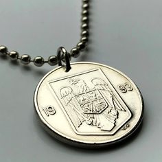 a silver necklace with a coin on it