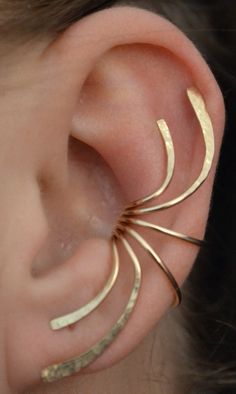 a close up of a person's ear with gold colored metal spirals