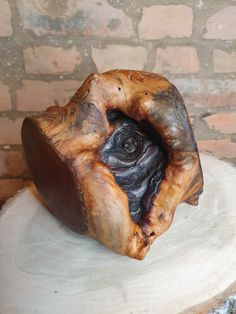 a piece of wood that has been carved into the shape of a human head on top of a tree stump