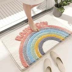 a woman standing on top of a bath rug next to slippers and a potted plant