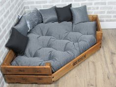 a futon bed made out of wooden pallets with pillows on the top and bottom