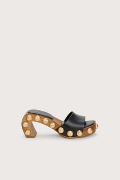 A sculptural mule designed with a curved wood frame, smooth leather straps and textured brushed brass studs. - Smooth nappa leather straps and sole - Moire textured brushed brass studs Unique Heels, Clear Shoes, Embroidered Flats, Luxury Designer Shoes, Swimming Bag, Shoe Inspo, Cult Gaia, Unique Shoes, Clothing Design