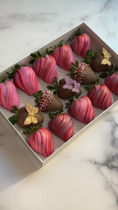 a box of chocolate covered strawberries on a marble counter top with butterflies and flowers