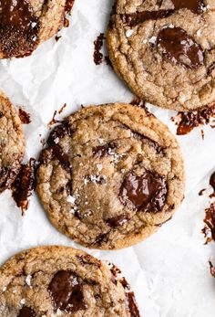 chocolate chip cookies on parchment paper with sea salt sprinkled on the top and bottom