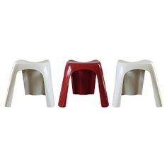 two white and red plastic stools sitting next to each other on a white background