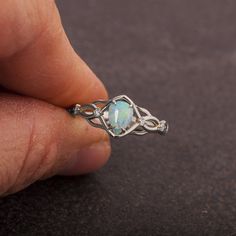 A handmade Celtic style engagement ring set with a natural Australian opal and 4 little diamonds. The ring is made with any of the available metals you select. All of the metals we use are 100% recycled. The opal is 100% natural Australian opal of high quality measuring 7mmX5mm The diamonds I use are high quality E-F color VS clarity white diamonds. The total carat weight is 0.04ct. If you have any questions please feel free to ask :) -----------------------VARIATIONS---------------------- The r Small Engagement Rings Opal, Opal Vintage Engagement Ring, Opal Wedding Ring Silver, Opal Ring With Bezel Setting, Unique Opal Promise Ring With Accent Stones, Opal Engagement Ring Silver, Wedding Ring Opal, Gold Opal Engagement Ring, Opal Wedding Ring