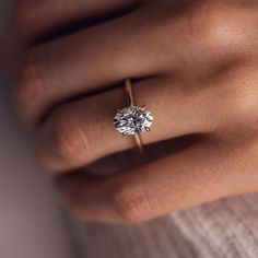 a woman's hand with a diamond ring on it