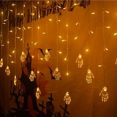 there are many lights hanging from the ceiling in front of a wall that is decorated with halloween decorations