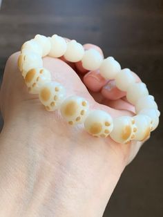 a close up of a person's hand holding a fake tooth with holes in it