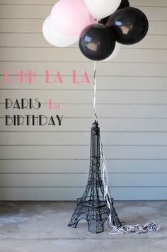 the eiffel tower has balloons floating from it's base to celebrate its birthday