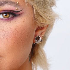 a woman with freckles and piercings on her face