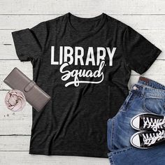 a t - shirt that says library squad next to some shoes