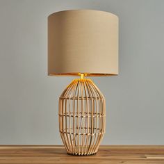 a lamp that is on top of a wooden table next to a light fixture with a beige shade