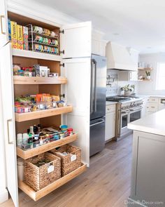 a kitchen with white cabinets and wooden shelves filled with food items on top of them