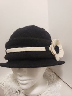 Black light weight wool hat in a large size.  It has a certain amount of stretch to it.  White accent band with two flowers.  Sort of a 1920s style.  You may want to sew a few of the flower petals together to keep the petals from flopping.  Hats are a fantastic way to complete your "look" tarpaperalley.etsy.com ------------------------------------------------------------------- For more hats and scarves https://www.etsy.com/ca/shop/TarPaperAlley?ref=seller-platform-mcnav&section_id=24644895 ---- Vintage Black Fedora Felt Hat, Vintage Wool Hat Bands For Winter, Adjustable Vintage Wool Hat Band, Fitted Vintage Black Hat Bands, Vintage Wool Cloche Hat For Winter, Vintage Black Wool Hats, Vintage Wool Cloche Hat With Curved Brim, Black Vintage Wool Felt Hat, Vintage Black Wool Felt Hat