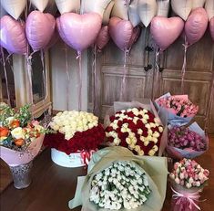 a bunch of flowers and balloons on a table