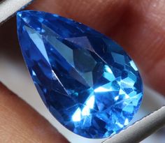 a blue diamond being held in someone's hand