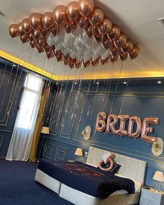 a bedroom decorated with balloons that spell bride and the word bride hanging from the ceiling